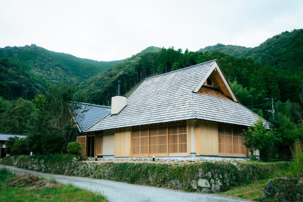 ザイツ建築株式会社の手がけた新築住宅の外観写真、屋根はレッドシダーハンドスプリットの屋根材、外壁は左官仕上げ、格子建具が３枚と２枚で２箇所ある