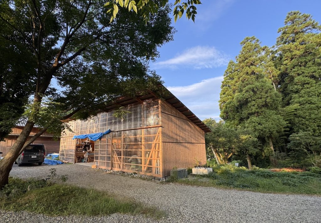 緑に囲まれた、ザイツ建築株式会社の本社のアトリエラボを右斜より撮影した写真